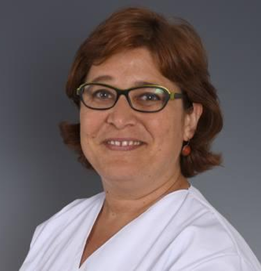 Mujer de mediana edad sonriente con gafas y pelo corto castaño con camiseta de médico blanca.