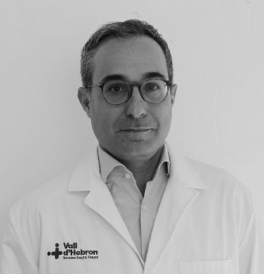 Hombre sonriente canoso con gafas y camisa blanca